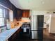 Charming kitchen with stainless steel appliances, dark wood cabinets, and an open doorway to the living room at 106 Walnut St, Southport, IN 46227