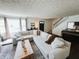 Bright living room featuring decorative ceiling, large sofa, and piano at 106 Walnut St, Southport, IN 46227