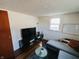 Cozy living room features a modern couch, sleek entertainment center, and natural light from a window at 106 Walnut St, Southport, IN 46227