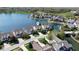 Aerial view of waterfront homes on a lake with mature trees and well-manicured lawns at 11484 Lake Stonebridge Ln, Fishers, IN 46037