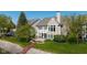 Expansive backyard with lush greenery, a wooden deck and stairs leading down to a waterfront area at 11484 Lake Stonebridge Ln, Fishers, IN 46037