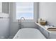 Well-lit bathroom features modern fixtures, including a sleek faucet and soaking tub under a bright window at 11484 Lake Stonebridge Ln, Fishers, IN 46037