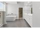 Bright bathroom with a soaking tub, double vanity, large mirror, and an open closet space for optimal storage at 11484 Lake Stonebridge Ln, Fishers, IN 46037