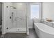 Modern bathroom boasts a sleek glass enclosed shower and soaking tub under a window offering natural light at 11484 Lake Stonebridge Ln, Fishers, IN 46037
