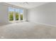 Large bedroom features neutral carpeting, crown molding, and large windows offering views of the trees at 11484 Lake Stonebridge Ln, Fishers, IN 46037
