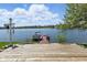 A waterfront view from a wooden dock with a boat, serene lake, and blue sky at 11484 Lake Stonebridge Ln, Fishers, IN 46037