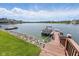 A boat is parked at a private boat dock on a sunny day with a blue sky and white clouds at 11484 Lake Stonebridge Ln, Fishers, IN 46037