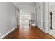 Open hallway with hardwood floors, leading to a bright living area and staircase in a well-lit home at 11484 Lake Stonebridge Ln, Fishers, IN 46037