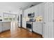 Bright kitchen with stainless steel appliances and white cabinetry with an open view to the living area at 11484 Lake Stonebridge Ln, Fishers, IN 46037