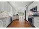 Bright kitchen featuring stainless appliances, white cabinetry, and an open view to a spacious living area at 11484 Lake Stonebridge Ln, Fishers, IN 46037