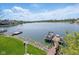 Expansive lake view featuring a private dock with boat, waterfront homes, and stunning mountain scenery in the background at 11484 Lake Stonebridge Ln, Fishers, IN 46037