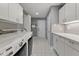 Well-organized laundry room features white cabinets, countertops, tiled floor, sink and modern washer and dryer at 11484 Lake Stonebridge Ln, Fishers, IN 46037