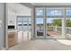 Living room with open layout, multiple windows with lake views, and access to an outdoor deck at 11484 Lake Stonebridge Ln, Fishers, IN 46037