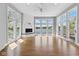 Bright, empty living room with hardwood floors, large windows showcasing a scenic waterfront view, and a fireplace at 11484 Lake Stonebridge Ln, Fishers, IN 46037