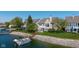 A waterfront home with a private dock and boat, complemented by the manicured backyard and stone embankment at 11484 Lake Stonebridge Ln, Fishers, IN 46037