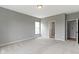 Spacious bedroom featuring neutral carpet, gray walls, a window and a glimpse into an adjoining bathroom at 11595 Platt St, Noblesville, IN 46060