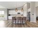 Well-lit kitchen featuring a spacious island, modern lighting fixtures, and stainless steel appliances at 11595 Platt St, Noblesville, IN 46060