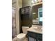 Bathroom with a shower with decorative shower door, vanity, and commode at 11748 E 10Th St, Indianapolis, IN 46229