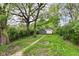 A long, narrow backyard with lush greenery leads to a detached garage, perfect for outdoor enjoyment at 1234 N Dearborn St, Indianapolis, IN 46201