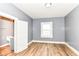 Bedroom with wood-look flooring, closet, and light-filled window at 1234 N Dearborn St, Indianapolis, IN 46201