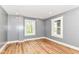 Cozy bedroom with hardwood floors, neutral paint, and natural light through two windows creating a serene space at 1234 N Dearborn St, Indianapolis, IN 46201