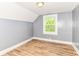 A carpetless bedroom with grey walls and white trim features a window with views of the outdoors at 1234 N Dearborn St, Indianapolis, IN 46201