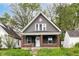 Charming home showcasing gray siding, brick accents, complemented by a well-manicured lawn and mature trees at 1234 N Dearborn St, Indianapolis, IN 46201