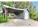 A detached garage with a carport area offers covered parking and storage in a lush backyard setting at 1234 N Dearborn St, Indianapolis, IN 46201