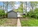A detached garage with a carport area offers covered parking and storage in a lush backyard setting at 1234 N Dearborn St, Indianapolis, IN 46201