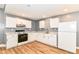 Efficient kitchen with white cabinets and appliances, wood floors, perfect for culinary adventures at 1234 N Dearborn St, Indianapolis, IN 46201
