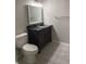 Bathroom with a dark vanity, a framed mirror, a toilet, and light grey paint on the walls at 12873 Tradd St # 2B, Carmel, IN 46032