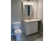 Bathroom features a vanity sink with white cabinets and a decorative mirror above the toilet at 12873 Tradd St # 2B, Carmel, IN 46032