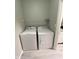 Functional laundry area with a white washer and dryer, a top rack for storage, and light grey paint at 12873 Tradd St # 2B, Carmel, IN 46032
