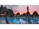 Community pool featuring a clubhouse, ample seating, and a picturesque view of the sunset sky at 12873 Tradd St # 2B, Carmel, IN 46032