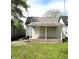 View of the backyard featuring a covered porch, green grass, and a wooden fence at 1303 9Th St, Columbus, IN 47201