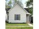 Exterior view of a cozy home with light siding, dark shutters, and a well-maintained lawn at 1303 9Th St, Columbus, IN 47201