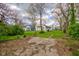 The property features a backyard with a grassy area leading to a white sided house with trees at 1467 W 33Rd St, Indianapolis, IN 46208