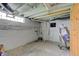 Unfinished basement with exposed pipes, painted walls and window provides an opportunity for customization at 1467 W 33Rd St, Indianapolis, IN 46208