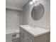 Updated bathroom featuring a modern vanity, round mirror, and tiled shower at 1467 W 33Rd St, Indianapolis, IN 46208
