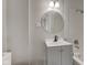 Bathroom featuring a gray vanity, round mirror, white tile walls, and shower-tub combo at 1467 W 33Rd St, Indianapolis, IN 46208