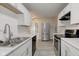 Well-lit kitchen featuring stainless steel appliances, sleek countertops, and white cabinets at 1467 W 33Rd St, Indianapolis, IN 46208