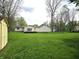 The backyard features a large manicured lawn, storage shed, mature trees, and access to the back of the house at 1506 Field Dr, Noblesville, IN 46060