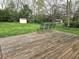 Expansive backyard view from the weathered wood deck featuring a lush green lawn, mature trees, and a storage shed at 1506 Field Dr, Noblesville, IN 46060