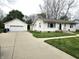 Charming home exterior featuring a well-manicured lawn, concrete driveway, and a detached garage, combining comfort and convenience at 1506 Field Dr, Noblesville, IN 46060