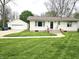 Home with green lawn and walkway leads to the home's front entrance and detached garage at 1506 Field Dr, Noblesville, IN 46060
