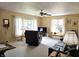Bright living room with neutral carpet, large windows, and a cozy seating area at 1506 Field Dr, Noblesville, IN 46060