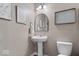 Charming powder room features a pedestal sink, decorative mirror, and elegant wall decor at 15332 Atkinson Dr, Noblesville, IN 46060