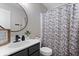 Modern bathroom featuring a round mirror, floral shower curtain, and black fixtures at 15332 Atkinson Dr, Noblesville, IN 46060