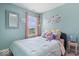 Bright bedroom with blue walls, light-colored bedding, and a large window at 15332 Atkinson Dr, Noblesville, IN 46060