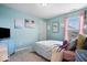 Bright bedroom with blue walls, light-colored bedding, and a view of the neighborhood at 15332 Atkinson Dr, Noblesville, IN 46060